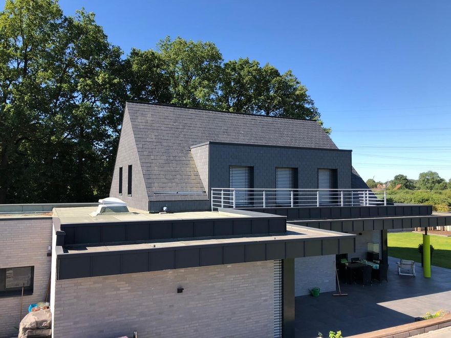 Ein Haus mit grauem Dach und Balkon