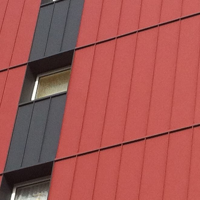 Hausfassade in grau und rot mit Fenstern