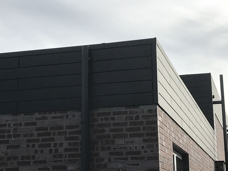 Backsteinhaus mit grauer Fassade und grauem Dach