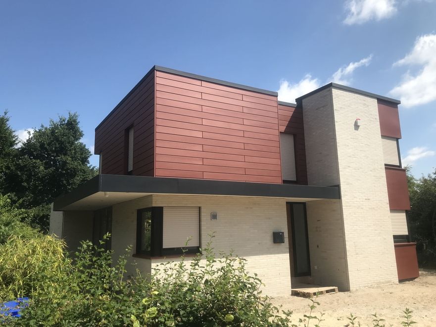 Bild eines Hauses mit rotbraunem Dach und Fassade